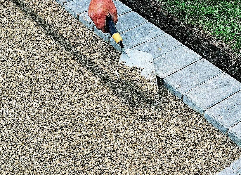 Recoloque a calçada com areia conforme necessário para preencher grandes rachaduras ou lacunas