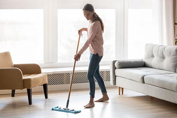 A sujeira da superfície do piso laminado usando o limpador