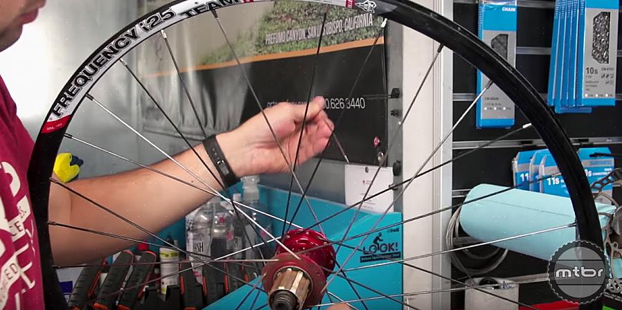 Pegue a roda da bicicleta com o raio quebrado removendo ou retirando-a do corpo da bicicleta