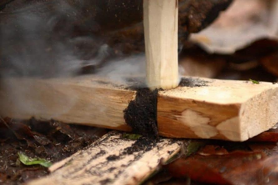 Continue adicionando pequenos pedaços de madeira até que eles pegem totalmente a chama