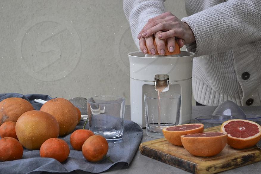 O processo para fazer suco de toranja com um espremedor manual é apenas apertar a meia seção contra