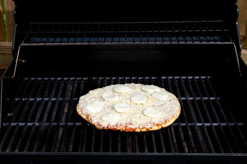 Experimente cozinhar sua pizza na churrasqueira a gás em vez de ficar dentro de casa perto do forno quente