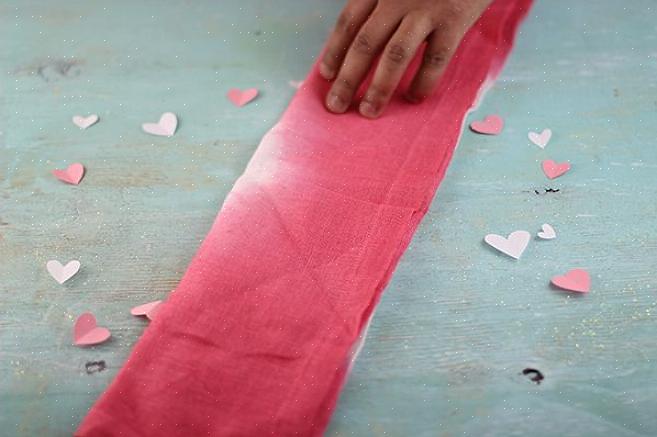 Uma maneira de fazer isso é dobrar os guardanapos de mesa em forma de coração