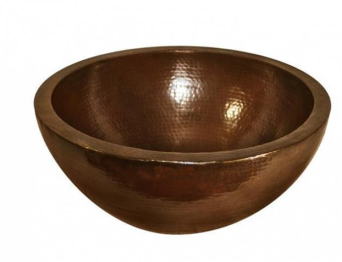 Uma pia de cobre martelado é feita martelando cobre aquecido na forma de uma pia