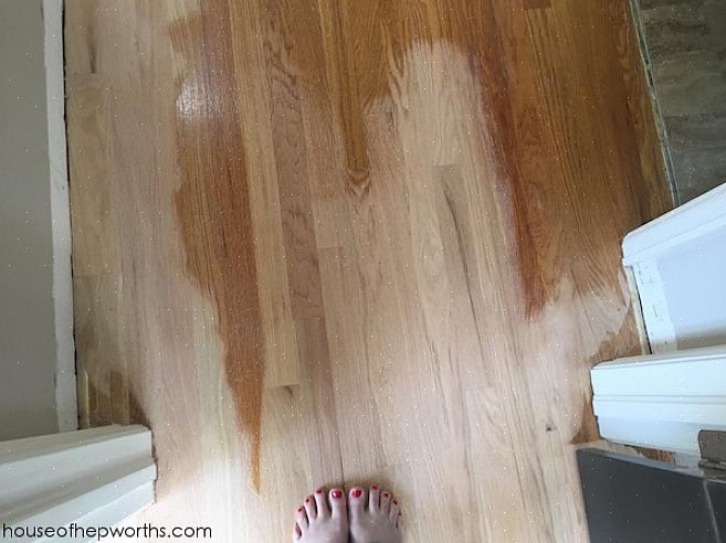 Coloque uma camada de resina de poliuretano no piso de madeira usando um esfregão de esponja